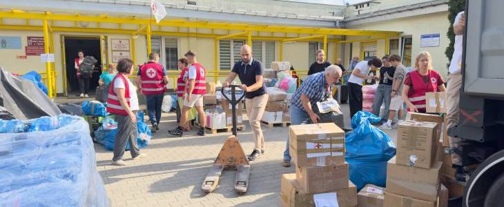 Zdjęcie przedstawia osoby pakujące dary dla powodzian